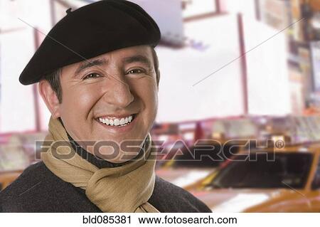 Stock Image - Hispanic man in beret on city street. Fotosearch