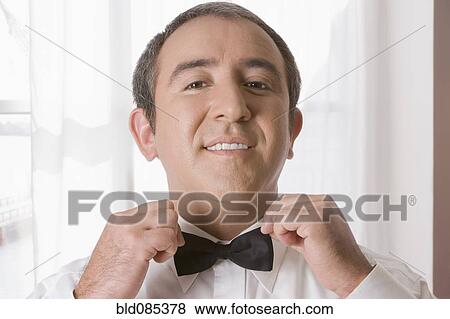 Hispanic man tying bow tie View Large Photo Image Stock Photo - Hispanic man tying bow tie. Fotosearch