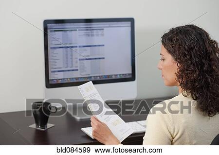Hispanic woman paying bills on computer View Large Photo Image Stock Photo - Hispanic woman paying bills on computer. Fotosearch