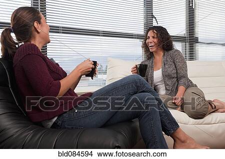 Picture - Hispanic women talking and drinking coffee. Fotosearch