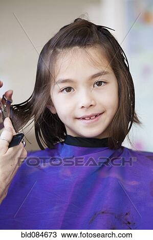 Mixed race girl getting her hair cut View Large Photo Image Stock Image - Mixed race girl getting her hair cut. Fotosearch