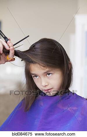 Stock Photography - Mixed race girl getting her hair cut. Fotosearch