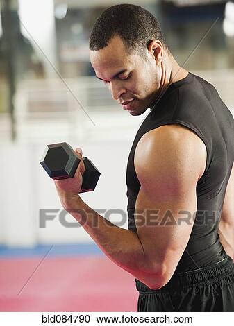 Mixed race man exercising with hand weights in health club View Large Photo Image Stock Image - Mixed race man exercising with hand weights in health club. Fotosearch