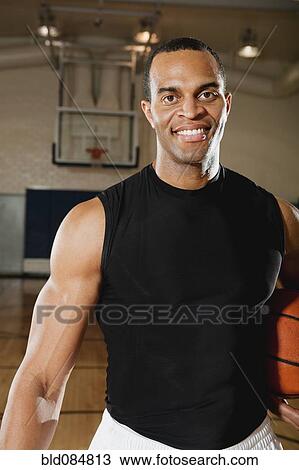 Mixed race man holding basketball on basketball court View Large Photo Image Stock Image - Mixed race man holding basketball on basketball court. Fotosearch