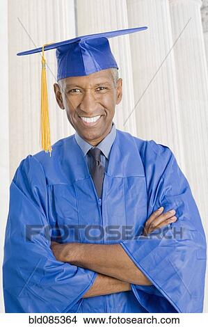 Picture - Mixed race man in graduation cap and gown. Fotosearch