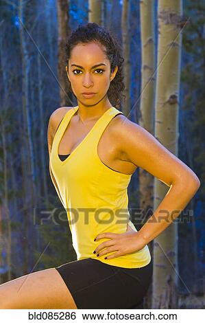 Stock Photograph - Mixed race runner standing in forest. Fotosearch