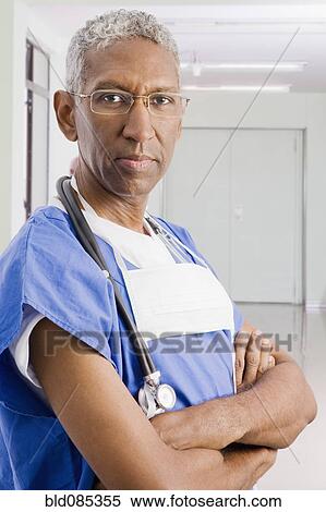 Stock Photography - Mixed race surgeon with arms crossed. Fotosearch