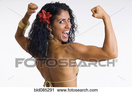 Stock Image - Mixed race woman body builder flexing muscles. Fotosearch