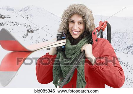 Mixed race woman carrying skis and poles View Large Photo Image Stock Photograph - Mixed race woman carrying skis and poles. Fotosearch