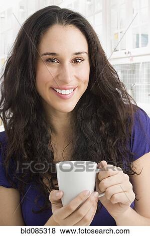 Stock Photo - Mixed race woman drinking coffee. Fotosearch