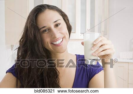 Stock Image - Mixed race woman drinking milk. Fotosearch