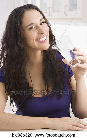 Stock Image - Mixed race woman drinking water. Fotosearch
