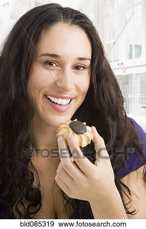Stock Photo - Mixed race woman eating a cookie. Fotosearch