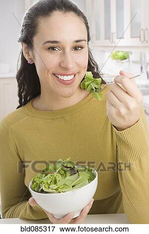 Stock Photo - Mixed race woman eating salad. Fotosearch