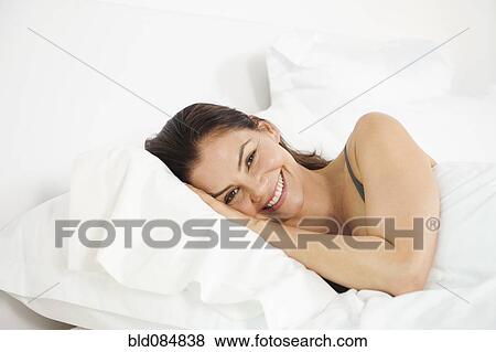 Stock Photo - Mixed race woman laying in bed. Fotosearch