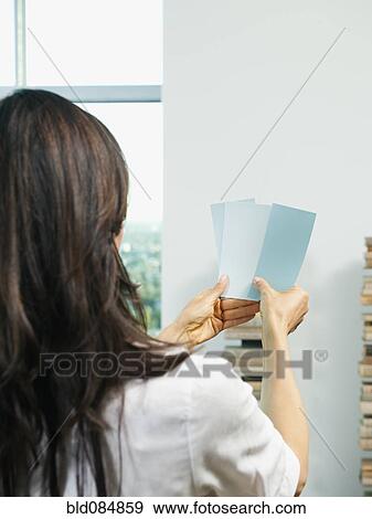 Stock Photo - Mixed race woman looking at color swatches. Fotosearch