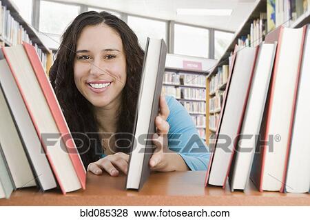 Mixed race woman looking for book in library View Large Photo Image Stock Photo - Mixed race woman looking for book in library. Fotosearch