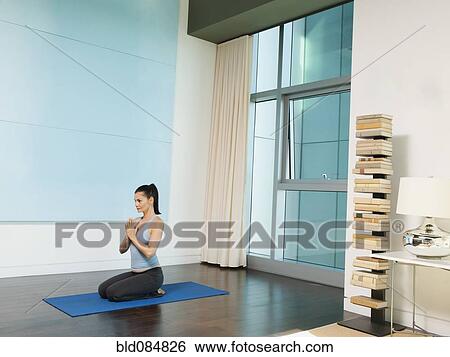 Stock Photograph - Mixed race woman practicing yoga. Fotosearch