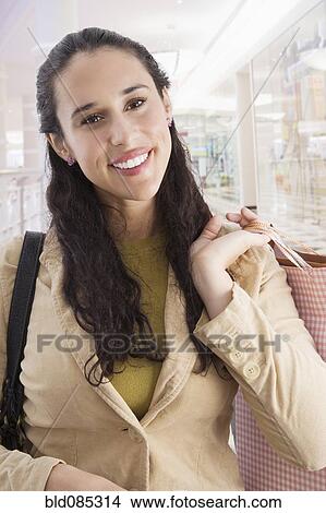 Mixed race woman shopping and carrying shopping bags View Large Photo Image Picture - Mixed race woman shopping and carrying shopping bags. Fotosearch