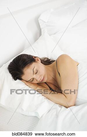 Stock Photo - Mixed race woman sleeping in bed. Fotosearch