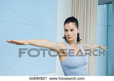 Stock Image - Mixed race woman standing with arms outstretched. Fotosearch