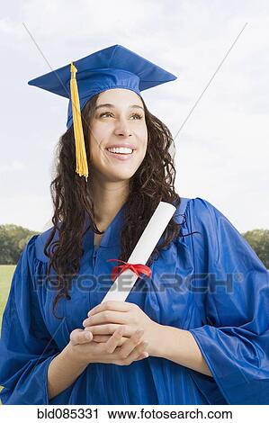 Mixed race woman wearing graduation cap and gown holding diploma View Large Photo Image Stock Image - Mixed race woman wearing graduation cap and gown holding diploma. Fotosearch