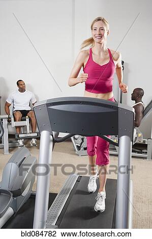 Stock Image - People exercising in health club. Fotosearch
