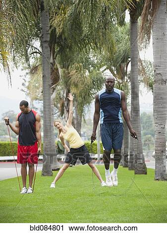 Stock Image - People exercising in park together. Fotosearch