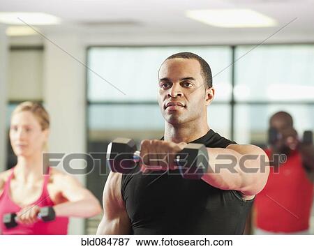 Stock Photo - People exercising with hand weights in health club. Fotosearch
