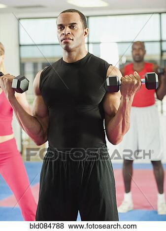 Stock Photo - People exercising with hand weights in health club. Fotosearch