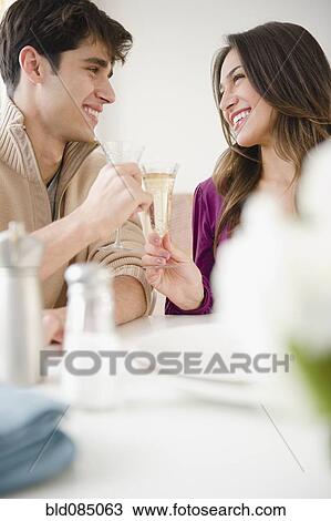 Stock Image - Smiling couple toasting with Champagne. Fotosearch