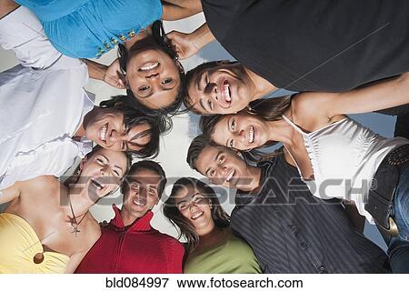 Stock Photo - Smiling friends in huddle together. Fotosearch