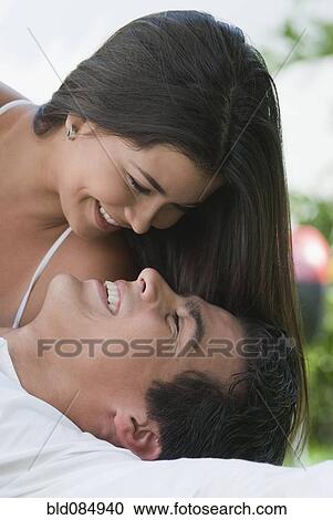 Stock Image - Smiling Hispanic couple looking at each other. Fotosearch