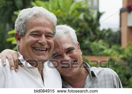 Stock Photography - Smiling Hispanic men hugging. Fotosearch