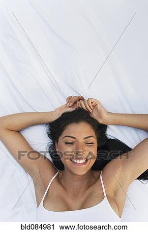 Smiling Hispanic woman laying in bed View Large Photo Image Stock Image - Smiling Hispanic woman laying in bed. Fotosearch