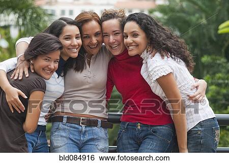 Stock Photograph - Smiling Hispanic women hugging. Fotosearch