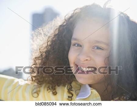 Picture - Smiling mixed race girl outdoors. Fotosearch