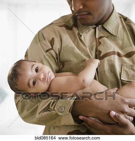 Picture - Solder in uniform holding baby boy. Fotosearch