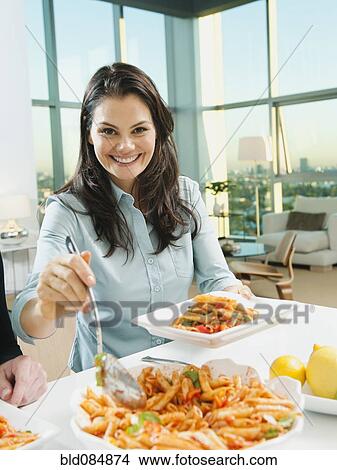Woman serving pasta at table View Large Photo Image Picture - Woman serving pasta at table. Fotosearch