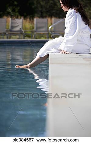 Stock Photo - Woman soaking feet in swimming pool. Fotosearch