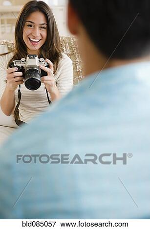 Stock Photo - Woman taking photograph of boyfriend. Fotosearch