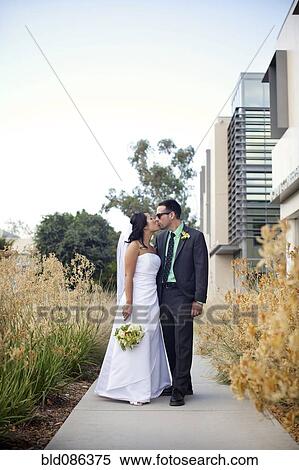 Bride and groom kissing on sidewalk View Large Photo Image Stock Photography - Bride and groom kissing on sidewalk. Fotosearch