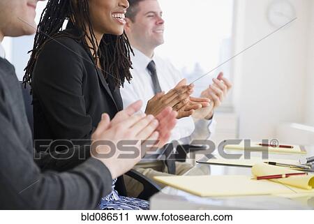 Stock Image - Business people clapping in meeting. Fotosearch
