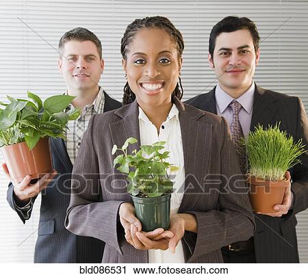 Business people holding potted plants View Large Photo Image Stock Image - Business people holding potted plants. Fotosearch