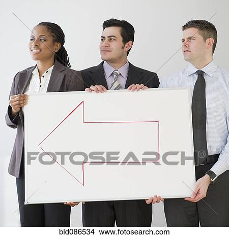 Business people holding whiteboard with arrow View Large Photo Image Picture - Business people holding whiteboard with arrow. Fotosearch