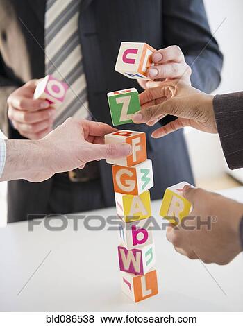 Stock Photo - Business people stacking alphabet blocks. Fotosearch