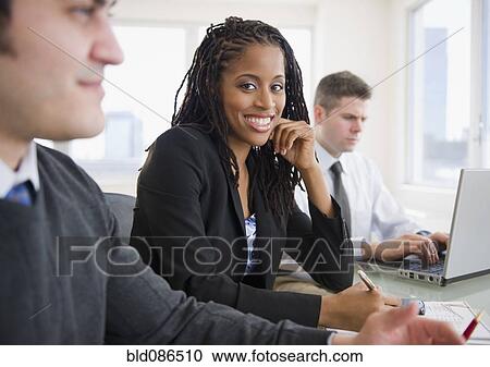 Stock Image - Business people working together in office. Fotosearch