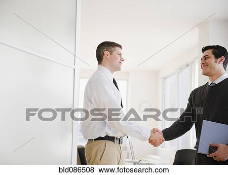 Businessmen shaking hands in office View Large Photo Image Stock Photo - Businessmen shaking hands in office. Fotosearch