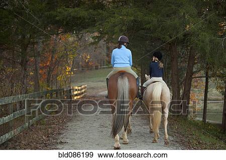Caucasian girl and trainer riding horses View Large Photo Image Stock Photo - Caucasian girl and trainer riding horses. Fotosearch