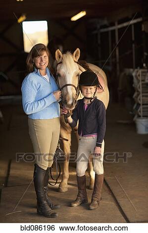 Caucasian girl and trainer standing with horse View Large Photo Image Stock Photograph - Caucasian girl and trainer standing with horse. Fotosearch
